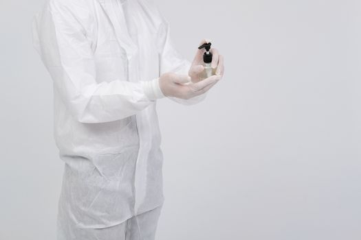 man doctor wearing biological protective uniform suit clothing, mask, gloves washing hand with sanitizer dispenser for sanitizing virus bacteria