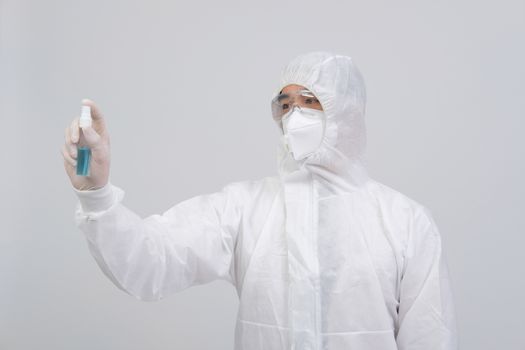 man doctor wearing biological protective uniform suit clothing, mask, gloves with hand alcohol sanitizer dispenser for sanitizing virus bacteria