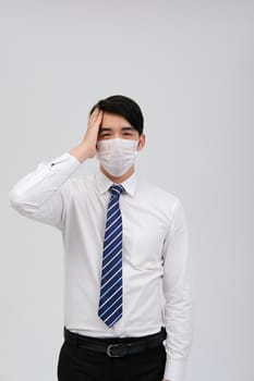 ill businessman man feeling sick, headache wearing protective mask against cold flu virus bacteria infection pollution