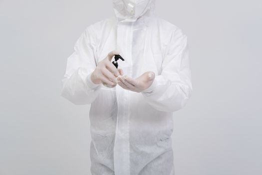 man doctor wearing biological protective uniform suit clothing, mask, gloves with hand alcohol sanitizer dispenser for sanitizing virus bacteria