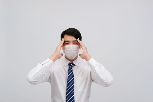 ill businessman man feeling sick, headache wearing protective mask against cold flu virus bacteria infection pollution