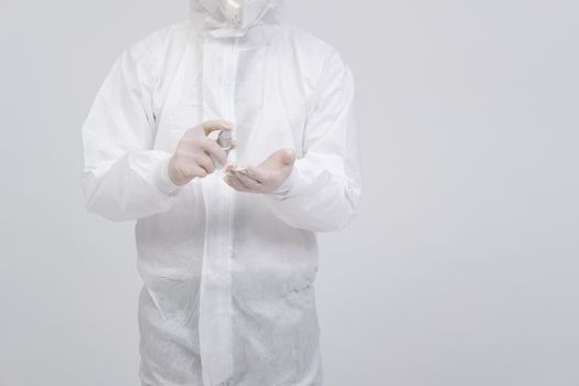 man doctor wearing biological protective uniform suit clothing, mask, gloves with hand alcohol sanitizer dispenser for sanitizing virus bacteria