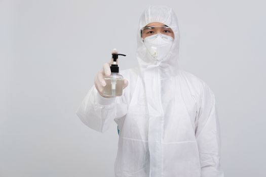 man doctor wearing biological protective uniform suit clothing, mask, gloves with hand sanitizer dispenser for sanitizing virus bacteria