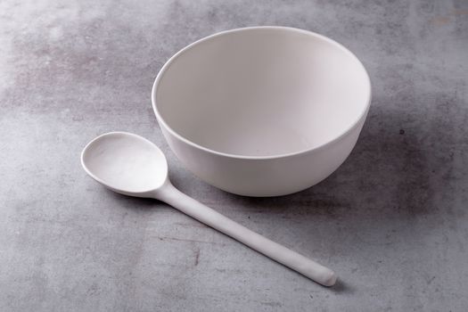 Empty blank white ceramic Bowl and spoon on Cement Board.