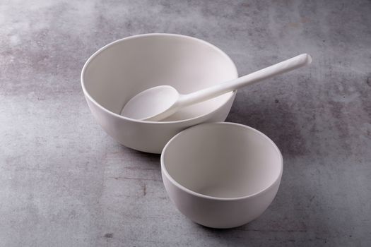 Empty blank white ceramic Bowl and spoon on Cement Board.