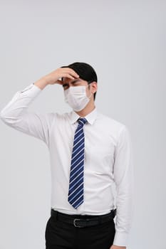 ill businessman man feeling sick, headache wearing protective mask against cold flu virus bacteria infection pollution