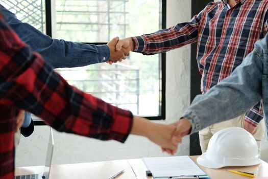 engineer team handshaking. architect shaking hands for successful deal in building construction project. teamwork cooperation concept