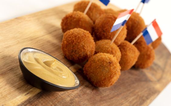 Dutch traditional snack bitterbal on a serving board, dutch flag, isolated