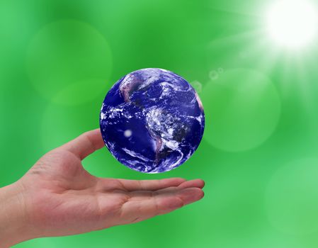 Love and care the earth concept, hand and blue planet on green blur background, Elements of this Image Furnished by NASA
