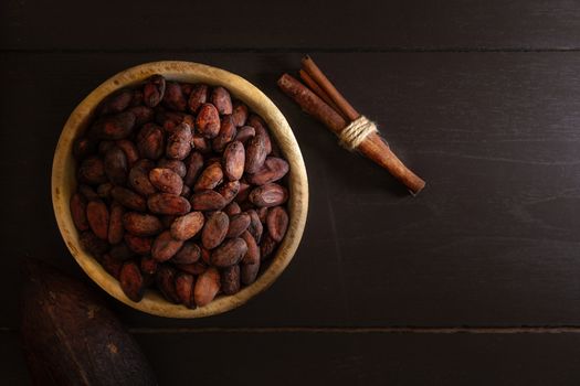 Top view of Cocoa beans in vintage table on dark background.