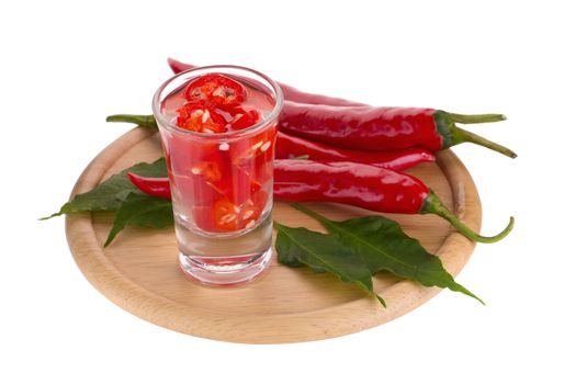 Slices of preserved red hot pepper in glass isolated on a white background.