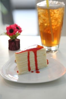 Crape cake pour with strawberry sauce on plate 