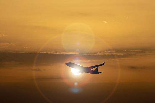 Silhouette of airplane on Colorful dramatic sky at Sunset.