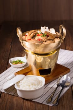 Chicken and herb soup in brass pan.