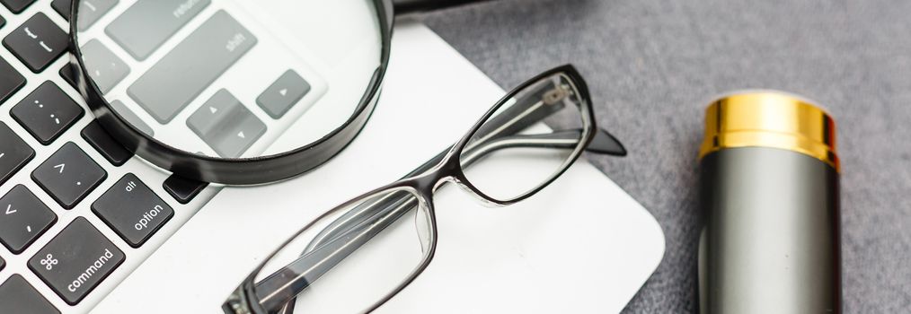 Business summary reports and a magnifying glass with glasses on table office. Concept of Data Analysis, Investment Planning, Business Analytics.