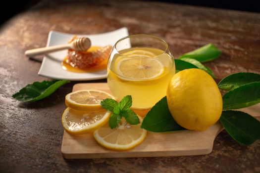 Lemon juice with honey on wooden table,  lemons and sage leaves.