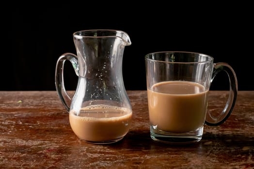 Transparent cup of coffee on a wooden vintage table.