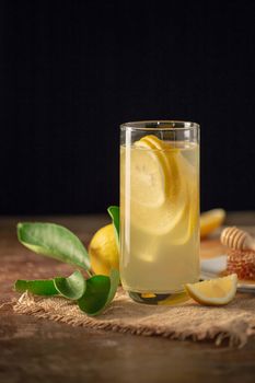 Lemon juice with honey on wooden table,  lemons and sage leaves.