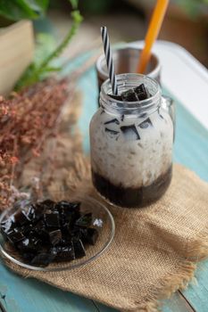 Glass of Fresh milk and Black grass jelly on top.