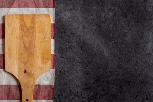 Wooden cutting board on black table background.