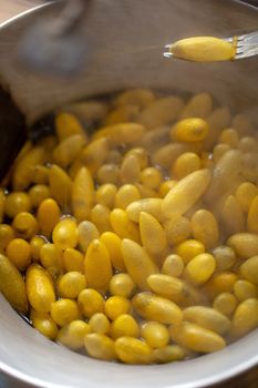 Boiling yellow silkworm cocoons by boiler to make silk thread.