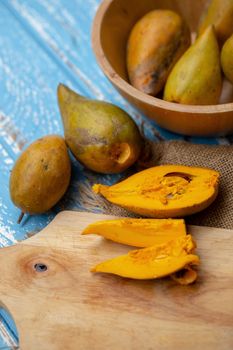 Egg fruit Canistel Yellow Sapote (Pouteria campechiana (Kunth) Baehni) on blue wooden table.