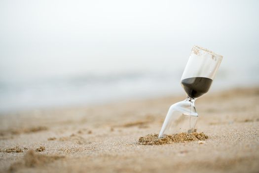 Sand clock on the beach, business time management concept