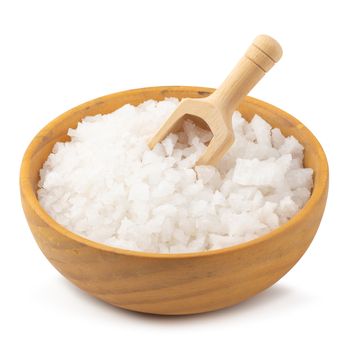 Organic sea white salt tablets in a wooden bowl on white background.