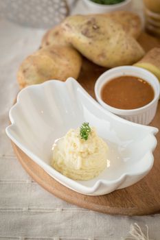 Mashed potatoes in a plate on a wooden table.