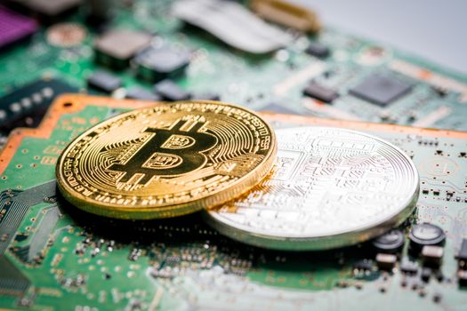 Bitcoin, the digital currency in studio on motherboard background