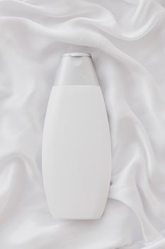 Blank label cosmetic container bottle as product mockup on white silk background, hygiene and healthcare