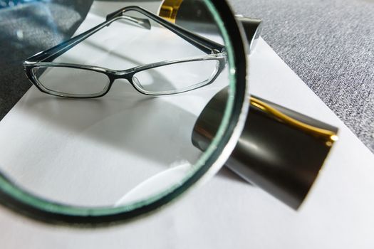 Business summary reports and a magnifying glass with glasses on table office. Concept of Data Analysis, Investment Planning, Business Analytics.