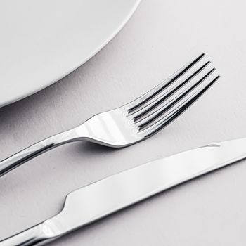 Empty plate and cutlery as mockup set on white background, top tableware for chef table decor and menu branding design