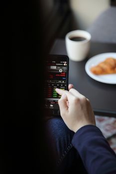 trading online on smartphone with business woman hand and coffee