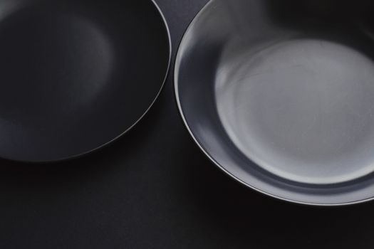 Empty plates on black background, premium dishware for holiday dinner, minimalistic design and diet concept