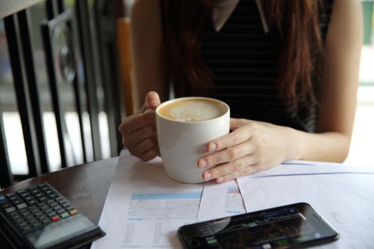A business woman hand with coffee and business paper