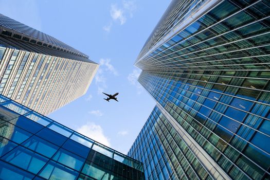 A jet airplane silhouette with business office towers background