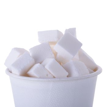 Sugar cubes in wooden spoon isolated on a white background.