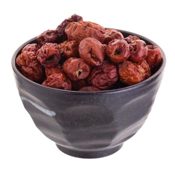 Dried jujube fruits in ceramic bowl chinese herbal medicine on a white background.