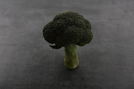 Vegetable broccoli isolated on dark rock background