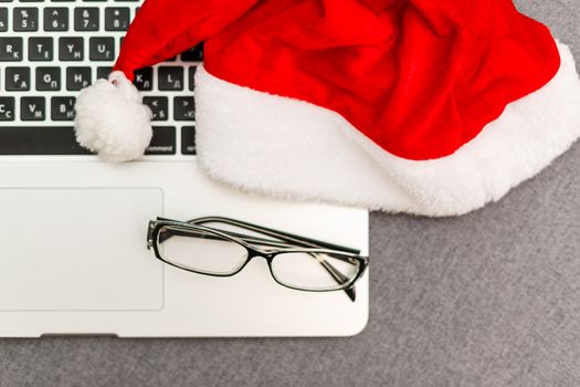 laptop keyboard. Work on the eve of the New Year. Top view, laptop keyboard, Santa hat, present