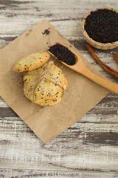 Sesame Cookies, sesame and milk on black wooden background.