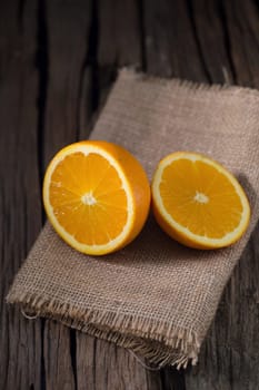 fresh orange and orange slices group on a dark wooden table.