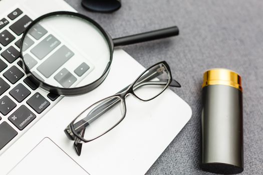 Business summary reports and a magnifying glass with glasses on table office. Concept of Data Analysis, Investment Planning, Business Analytics.