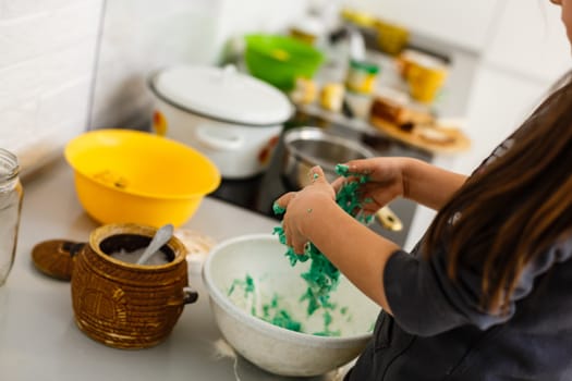 Little cute girl is cooking on kitchen. Having fun while making cakes and cookies. Smiling