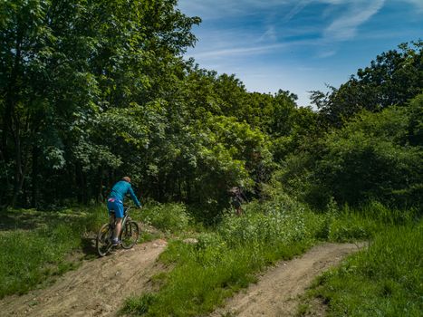 Two mens at edge of hill ride downhill in park