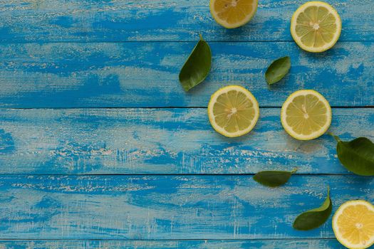 Yellow lemon on a blue wooden background. Top view.