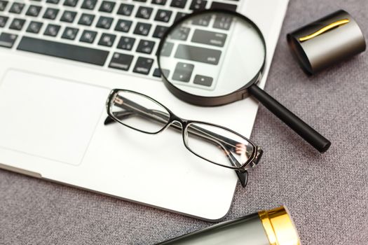 magnifier and glasses on a sheet of paper for business behind blind