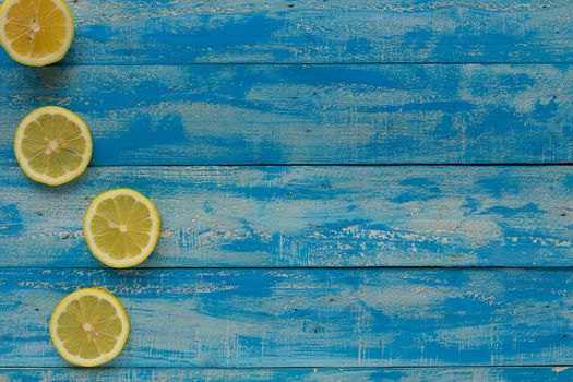 Yellow lemon on a blue wooden background. Top view.
