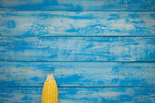 Ripe Corn on a blue wooden table top view.
